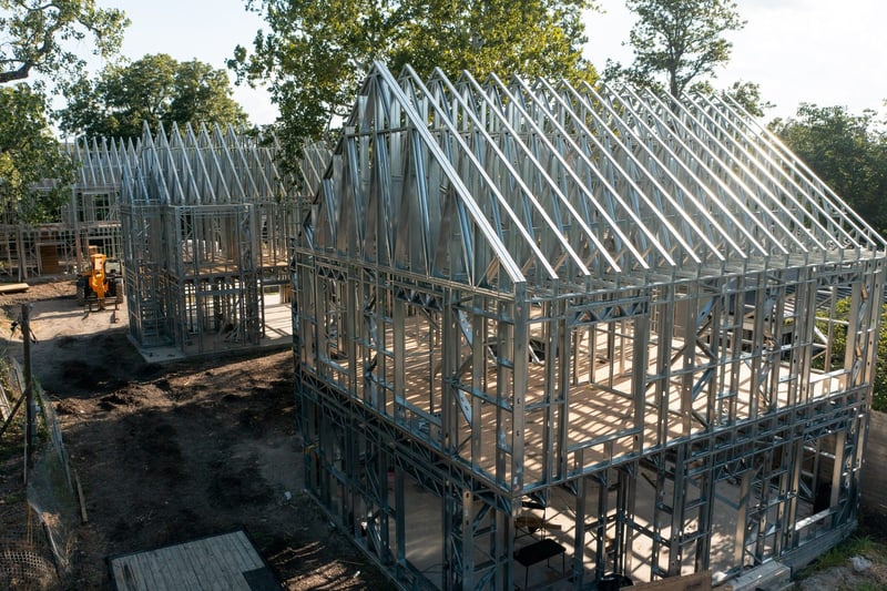 Aerial view of three steel-framed homes under construction in South Austin
